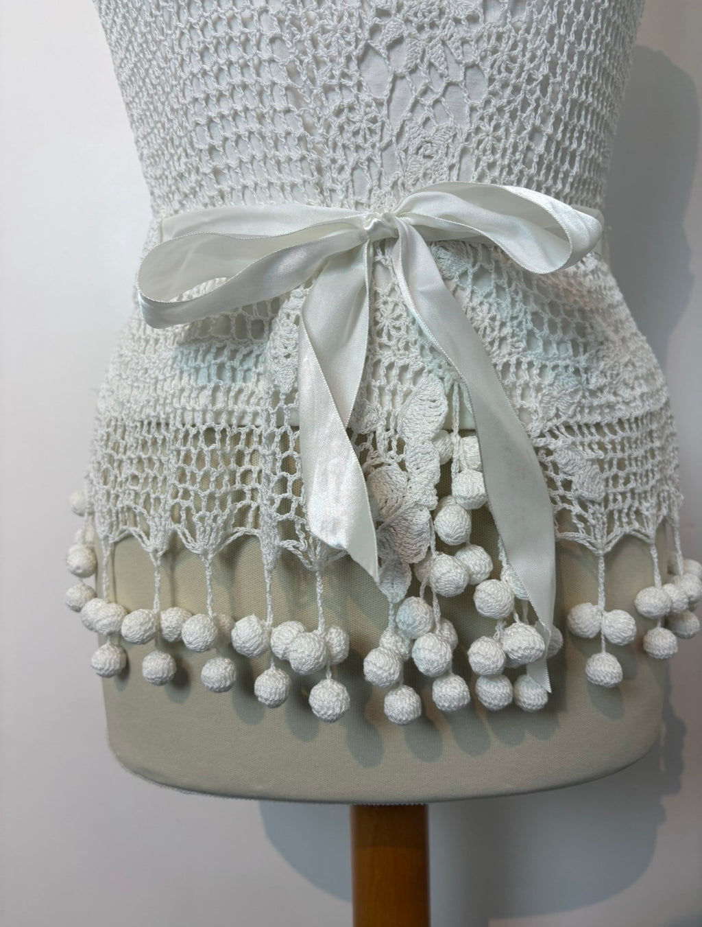 Handmade white crochet tie-up sleeveless top with tassel pom-poms